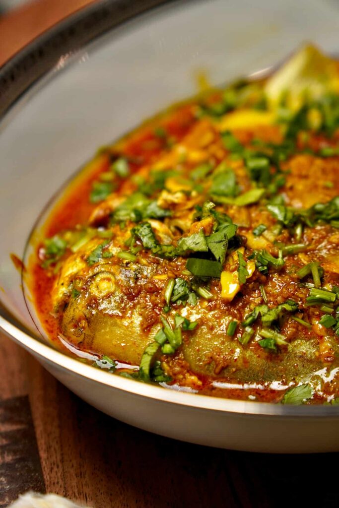 Plated Pomfret Fish Curry served with fresh coriander, highlighting the creamy texture of the curry.
