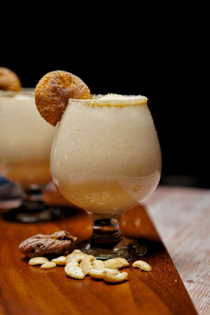 Garnished Kaju Anjeer Milkshake with crushed cashews and fresh figs.