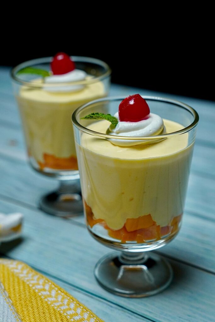 Close-up view of Heavenly Mango Mousse, highlighting the smooth and airy texture topped with whipped cream.