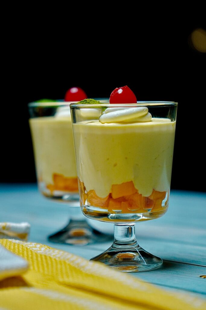 Layered Heavenly Mango Mousse in clear serving cups, featuring diced mango at the bottom and creamy mousse on top.